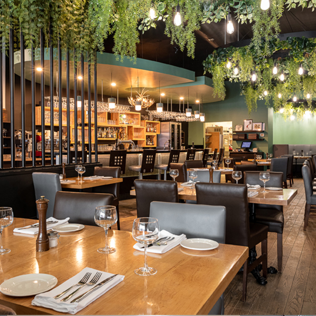 Restaurant dining room with set tables and a bar