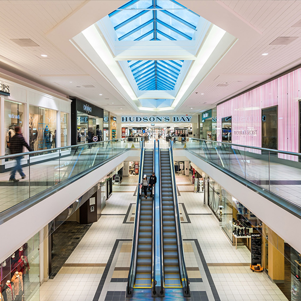 Interior of a shopping mall with escalators and storefronts